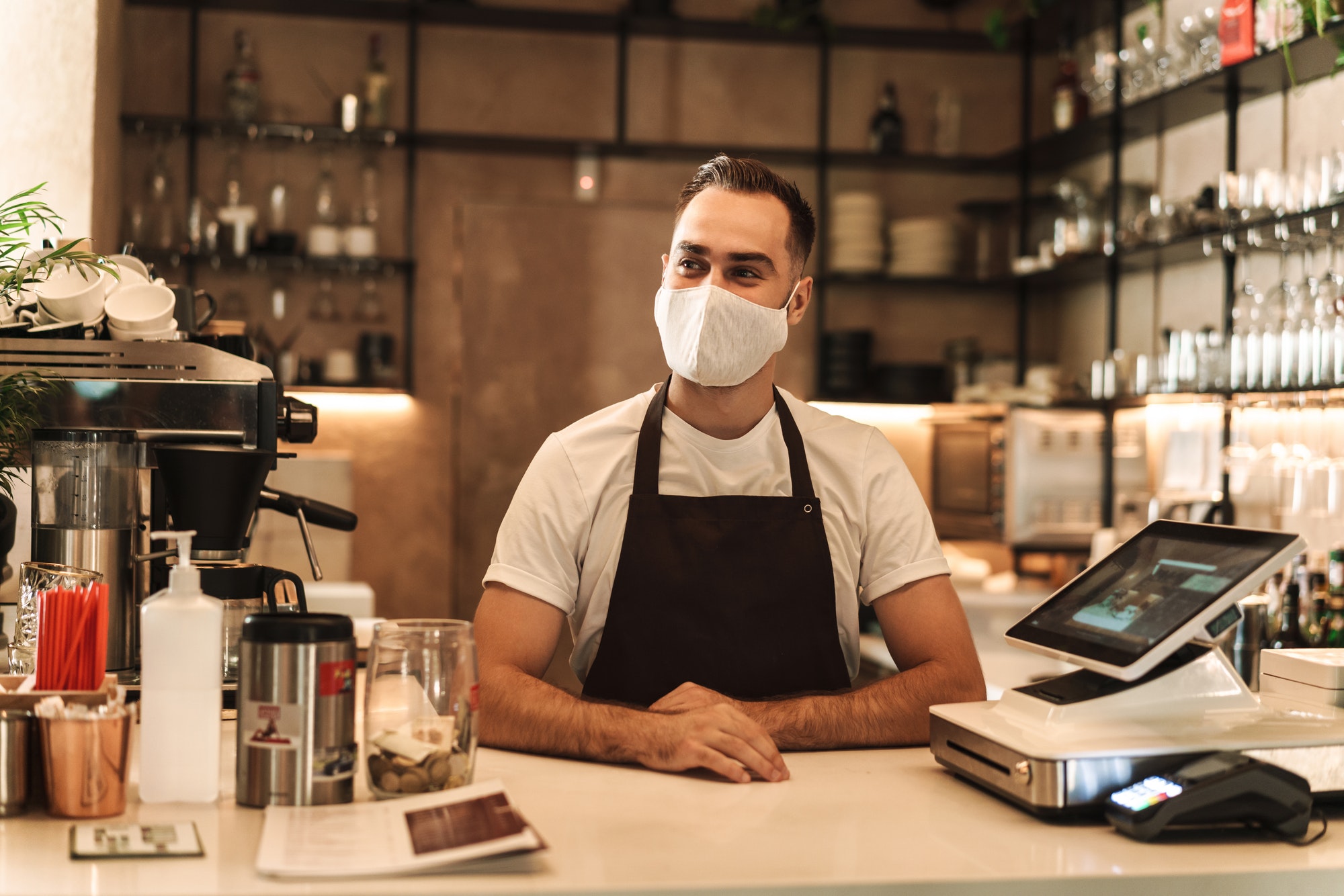 Barista with face mask in coffee shop, lockdown, quarantine, coronavirus, back to normal concept